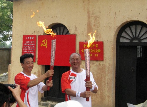7月29日,火炬手趙渭忠(右)與下一棒火炬手吳顯國展示火炬。當日,北京奧運圣火在河北省石家莊市傳遞。 新華社記者 曲瀾娟 攝