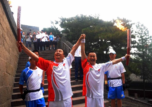8月7日,第一棒火炬手李中華(右二)與下一棒火炬手黨強(qiáng)交接后合影。當(dāng)日,北京奧運(yùn)圣火在北京市傳遞。 新華社記者 安治平 攝