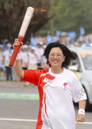 8月8日,火炬手張明手持火炬?zhèn)鬟f。當(dāng)日,北京奧運(yùn)圣火在北京市傳遞。 新華社記者 邢廣利 攝