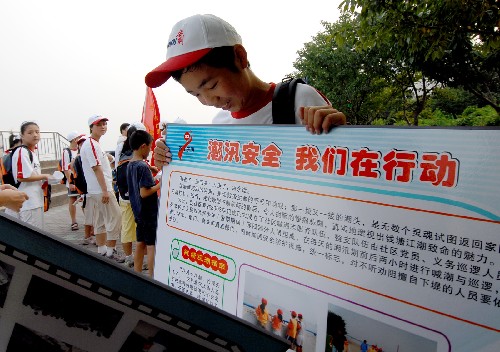 8月18日,來(lái)自西安的初二學(xué)生崔海明在錢(qián)塘江邊搬運(yùn)防潮宣傳展板。暑假期間,杭州市上城區(qū)望江街道組織了近30名外來(lái)務(wù)工人員子女參加“防潮夏令營(yíng)”,召集志愿者對(duì)他們宣講錢(qián)塘江潮水的危險(xiǎn)性,以避免不幸發(fā)生。 新華社記者 黃深鋼 攝