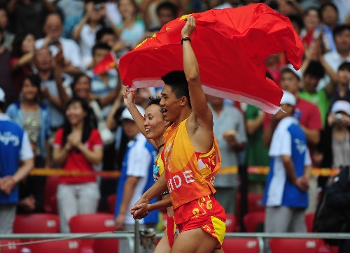 9月9日,中國選手吳春苗(左)與領跑員在比賽后繞場慶祝。當日,在國家體育場進行的北京2008年殘奧會女子100米T11級決賽中,吳春苗以12秒31的成績奪得冠軍。 新華社記者 李尕 攝