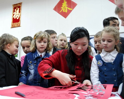1月22日,在白俄羅斯首都明斯克市,白俄羅斯國立藝術研究院中國留學生孟麗(前右二)為白俄羅斯小朋友表演中國傳統(tǒng)手工藝――剪紙。當天,在白俄羅斯歷史文化博物館,明斯克市百余名學習漢語的學生和中國留學生及中國駐白俄羅斯大使館的工作人員一起體驗中國春節(jié)。 新華社記者 高帆 攝