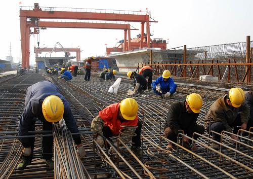 2月20日,工人們在京滬高鐵鎮(zhèn)江制梁場工地緊張施工。 近日,京滬高鐵鎮(zhèn)江制梁場全力以赴投入生產(chǎn),確保每天有兩孔箱梁出場。該場目前生產(chǎn)的這種單片重約900噸的箱梁是由我國自主創(chuàng)新設(shè)計的,適用于列車時速350公里/小時以上。京滬高鐵在鎮(zhèn)江境內(nèi)需要架設(shè)1000多片這樣的箱梁。 新華社發(fā)(陳崗 攝)