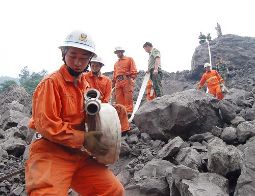 6月7日,幾名消防戰(zhàn)士在山體垮塌現(xiàn)場鋪設(shè)水帶。6月7日,重慶消防部隊30多名消防官兵克服重重困難,從山體垮塌現(xiàn)場兩個方向向位于鐵礦礦井口一帶的爆破點鋪設(shè)了約860多米的“生命水帶”。這兩條水帶穿過怪石嶙峋的山體垮塌現(xiàn)場,不間斷地為鉆填埋爆破火藥炸孔的鉆頭進行冷卻。新華社發(fā)(蔣勇攝)