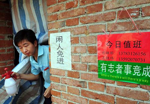 6月6日,河南省嵩縣何村鄉(xiāng)的“大學生村官”王鐵偉在完成了消毒工作后走出食用菌生產(chǎn)車間。 新華社記者 王頌 攝