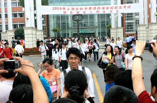6月9日,上海一些學(xué)生家長給從考點(diǎn)里走出來的考生拍照留念。新華社記者 陳飛 攝