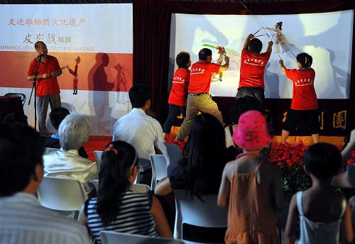7月11日,來自北京皮影劇團的老師在現場演示幕后如何操控皮影。 新華社記者 羅曉光 攝