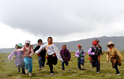“頓珠第二希望小學(xué)”的學(xué)生們在草原上奔跑(8月1日攝)。新華社記者格桑達(dá)瓦攝