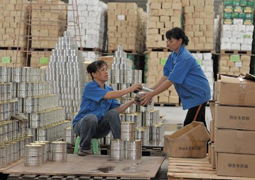 8月4日,在廣西橫縣六景工業(yè)園區(qū)一家罐頭食品廠,工人在將準(zhǔn)備出口的甜玉米罐頭裝箱。新華社記者 周華 攝