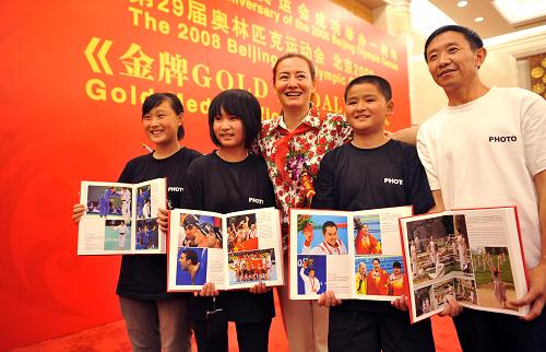 8月8日,《金牌》編著者楊子(中)向四川汶川什邡市中學(xué)師生代表贈送畫冊。當(dāng)日,一部由人民體育出版社出版,以競技體育為主,全面反映2008年北京奧運會成功舉辦的大型畫冊《金牌》首發(fā)式在北京人民大會堂舉行。新華社記者陳曉偉攝
