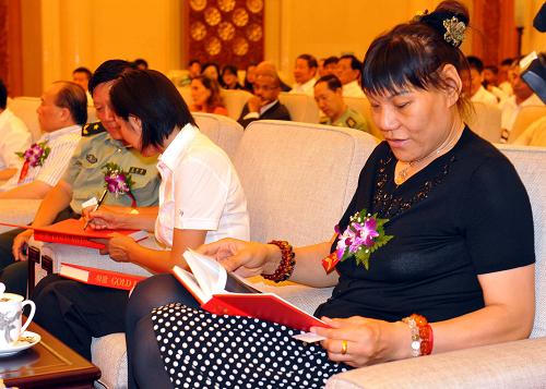 8月8日,著名女籃運動員鄭海霞(右)翻閱畫冊《金牌》。新華社記者陳曉偉攝