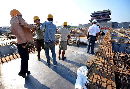 8月12日,工人在北京永定門廣場施工。當(dāng)日,北京永定門廣場工程的鋼箱梁頂推工程順利結(jié)束,九根鋼箱梁頂推到位。永定門廣場鋼箱梁頂推工程是整個永定門廣場架子結(jié)構(gòu)的重要組成部分,九根鋼箱梁架設(shè)的橋面總寬69米,長121.3米。永定門廣場工程是北京市2009年重點建設(shè)項目之一,該廣場建在南二環(huán)和護(hù)城河上方,在傳統(tǒng)北京南中軸線上形成一個凌空的“空中花園”,總占地2.2萬平方米,相當(dāng)于3個足球場大小。工程預(yù)計9月底完工。新華社記者羅曉光攝