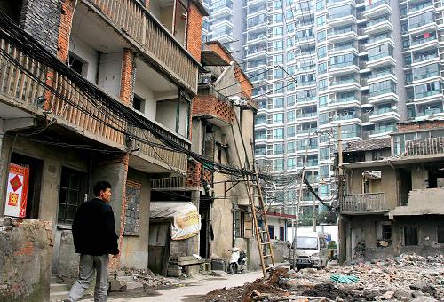 上海市長寧路旁的老式居民區(qū)拆遷工地(3月19日攝)。2009年3月,上海出臺(tái)的《關(guān)于進(jìn)一步推進(jìn)本市舊區(qū)改造工作的若干意見》舉行新聞通氣會(huì)。該意見規(guī)定只有同意改造的居民戶數(shù)超過規(guī)定比例才能啟動(dòng)改造,首次制定了舊區(qū)改造前要事先征詢、就近安置、完善補(bǔ)償三大創(chuàng)新機(jī)制,并將引入第三方全程監(jiān)督,邀人大代表、政協(xié)委員參與監(jiān)督舊區(qū)改造。新華社記者 戴浩攝