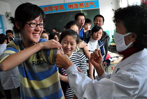 10月28日,黑龍江省牡丹江市東寧縣疾病預(yù)防控制中心的工作人員為該縣第一中學(xué)高三年級學(xué)生接種甲型H1N1流感疫苗。自當(dāng)日起,黑龍江省開始為首批重點人群免費接種甲型H1N1流感疫苗。首批疫苗共有64萬份。優(yōu)先接種人群包括關(guān)鍵崗位的公共服務(wù)人員,如一線醫(yī)療衛(wèi)生服務(wù)、鐵路、民航等工作人員,學(xué)生及教師等。新華社發(fā)(田成明 攝)