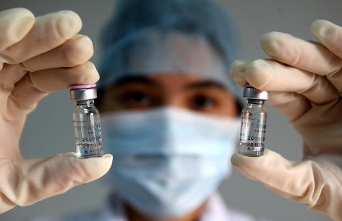 10月28日,廣東省東莞市疾控中心的工作人員展示甲型H1N1流感疫苗。據(jù)了解,東莞首批2萬份“甲流”疫苗已于27日運達。東莞將有50萬份“甲流”疫苗配額,分兩批為重點人群接種。新華社發(fā)(陳帆 攝)