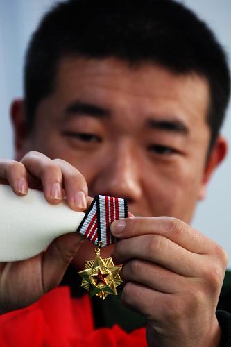 11月24日,秦皇島邊防檢查站即將退伍的老兵戴立強(qiáng)擦拭著自己的軍功章。新華社記者 楊世堯 攝