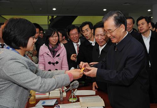 這是11月29日,溫家寶在南京工業(yè)大學考察時,學生向他贈送校徽紀念章。新華社記者饒愛民攝