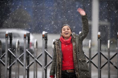 1月5日,在湖北武漢市,一名女青年迎著飛雪向同伴揮手。當(dāng)日,隨著強(qiáng)冷空氣的南下,湖北大部分地區(qū)迎來2010年的第一場(chǎng)降雪。新華社記者 郝同前 攝