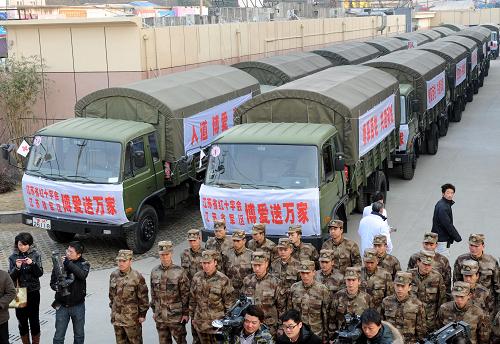 1月8日,部隊(duì)?wèi)?zhàn)士在滿載慰問物資的車隊(duì)前集合準(zhǔn)備出發(fā)。當(dāng)日,江蘇省紅十字會啟動新年“紅十字博愛送萬家”扶貧濟(jì)困活動。江蘇省軍區(qū)調(diào)派軍車,將首批價(jià)值660多萬元的大米、食用油、棉衣、棉被等物資,送往省內(nèi)經(jīng)濟(jì)薄弱地區(qū)部分困難群眾手中。新華社記者孫參攝