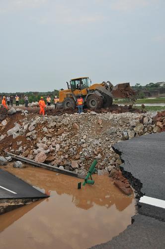 6月21日,工程人員在搶修滬昆高速公路江西余江境內(nèi)被洪水沖毀的路段。當(dāng)日下午6點(diǎn),經(jīng)工程人員的努力,滬昆高速江西余江境內(nèi)被沖毀的路段中斷了36個小時后終于搶通,該路段當(dāng)晚將恢復(fù)普通車輛通行,并在兩個月后完全修復(fù)。6月20日早上6點(diǎn),由于連日暴雨,滬昆高速公路江西余江縣境內(nèi)共有四處被洪水沖毀,并造成一輛大巴被沖出路面,5人受傷,一名5歲兒童死亡,滬昆高速被迫中斷。新華社記者 周密攝