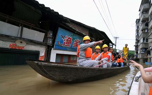 6月24日,湘潭電業(yè)局職工乘船查看進水后窯灣的供電線路。新華社記者 趙眾志 攝