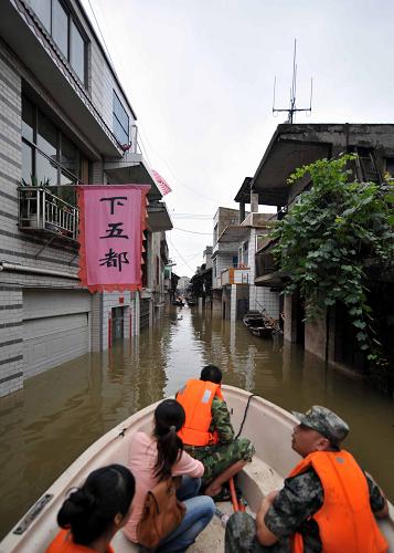 6月24日,當?shù)匚溲b部的救援人員乘沖峰舟進入被水淹沒的窯灣轉移居民。新華社記者 趙眾志 攝