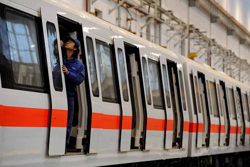 在南車株機(jī)公司車間內(nèi),一名工人正在一輛即將下線的城軌車輛車廂里工作(1月18日攝)。新華社記者李尕?cái)z