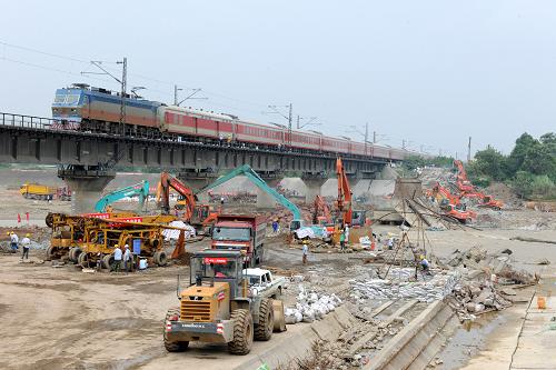 8月24日,施工人員在寶成鐵路石亭江大橋附近加緊施工。 目前,被洪水沖毀斷道的寶成鐵路廣漢段石亭江大橋舊橋已基本拆除,新橋開始鉆孔基礎(chǔ)施工。由于寶成鐵路是復(fù)線,盡管下行運(yùn)輸路線在廣漢境內(nèi)暫時(shí)中斷,但客貨列車還是能夠通過上行路線正常運(yùn)行通車。 8月19日,寶成鐵路廣漢段石亭江大橋橋墩被洪水沖垮,造成列車脫軌事故,幸無人員傷亡。損毀的舊橋被拆除,鐵路段內(nèi)將建設(shè)一座300米長(zhǎng)的鋼筋混凝土新橋。 新華社發(fā)(張長(zhǎng)明 攝)