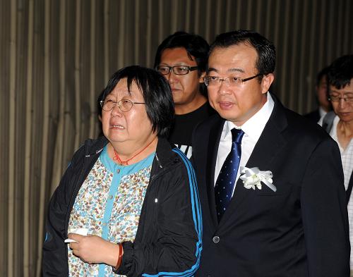 8月25日,在菲律賓首都馬尼拉的國際機場,中國駐菲律賓大使劉建超(右)陪同香港旅行團團員家屬出席悼念活動。新華社記者黃本強攝