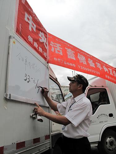 9月3日,工作人員在書(shū)寫(xiě)當(dāng)日直銷(xiāo)肉價(jià)。新華社記者 賀占軍 攝