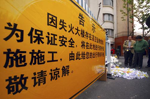 11月24日,市民在已封閉管理的上海“11·15”特別重大火災(zāi)事發(fā)大樓外獻(xiàn)花。新華社發(fā)(鈕一新 攝)