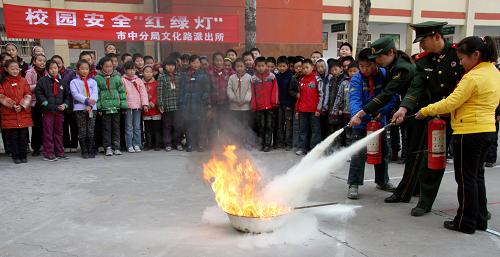 11月25日,消防官兵在棗莊市文化路小學(xué)指導(dǎo)學(xué)生進行滅火演練。新華社發(fā)