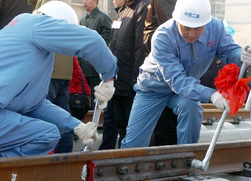 12月16日,中鐵二局的施工人員在鋪設(shè)京津城際鐵路最后一根鐵軌。 新華社記者 王曄彪 攝