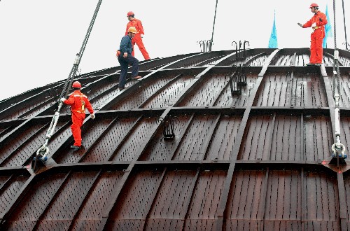 12月28日,工人們在即將起吊的秦山核電二期擴建工程3號反應堆穹頂上檢查。 新華社記者 譚進 攝