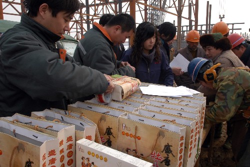 1月26日上午,在河南洛陽一工地上,幾位春節(jié)留守農(nóng)民工填寫速遞單,準(zhǔn)備把當(dāng)?shù)靥禺a(chǎn)牡丹餅寄給家里人。 新華社發(fā)(高山岳 攝)
