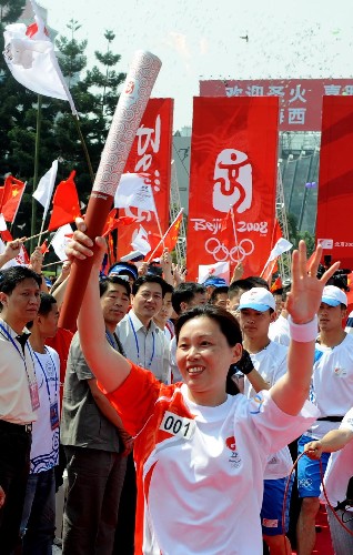 5月11日,第一棒火炬手鄭美珠手持火炬開(kāi)始傳遞。 新華社記者 張國(guó)俊 攝