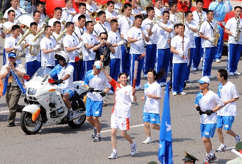 5月11日,第一棒火炬手鄭美珠在進(jìn)行傳遞。 新華社記者 姜克紅 攝