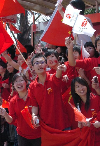5月11日,福建師范大學(xué)的學(xué)生為火炬?zhèn)鬟f加油。 新華社記者 張生貴 攝