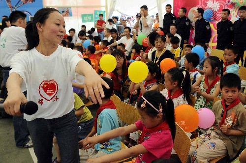 6月1日,來自綿陽外國(guó)語學(xué)校的老師在和小學(xué)生們聯(lián)歡。當(dāng)日,來自四川安縣、北川、江油等地震重災(zāi)區(qū)的兒童相聚在綿陽九洲體育館的帳篷學(xué)校里,度過一個(gè)特殊的兒童節(jié)。 新華社記者 陳凱 攝