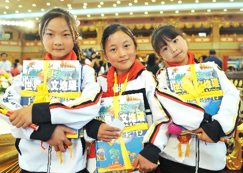 6月1日,3位來自四川的小學生捧著剛收到的兒童節(jié)禮物合影。當日,500名來自四川地震災區(qū)的小學生在昆明世博吉鑫園,與新朋友一起參加“手拉手·并肩走”慶“六一”演出活動。 新華社記者鄒崢攝