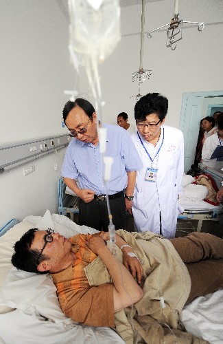 7月21日,昆明公交車爆炸案中的一位受傷者(下)在昆明醫(yī)學(xué)院第一附屬醫(yī)院與醫(yī)生及探視者交談。當(dāng)日,昆明市發(fā)生兩起公交車爆炸事故,14位受傷人員隨即被送入當(dāng)?shù)蒯t(yī)療條件最好的醫(yī)院得到全力救治。目前除一位重傷員仍在監(jiān)護(hù)中外,其他傷員的生命體征平穩(wěn)。 新華社記者鄒崢攝