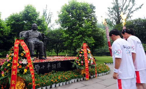 8月3日,火炬手陳靜(右)與李良國交接后向鄧小平銅像鞠躬。當(dāng)日,北京奧運(yùn)圣火在四川省廣安市傳遞。 新華社記者劉力航攝