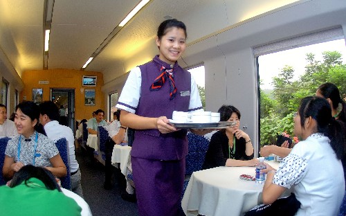 8月12日,“和諧長(zhǎng)城號(hào)”列車上的餐車服務(wù)員在為乘客服務(wù)。 新華社記者 李文 攝