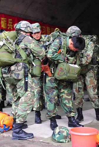 9月25日,參加演習(xí)的傘兵在登機(jī)前檢查裝備。 新華社發(fā)(沈玲 攝)