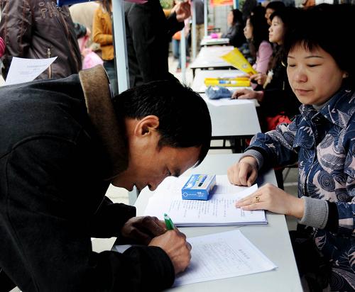 2月16日,來(lái)自四川達(dá)州的農(nóng)民工李先華在填寫(xiě)求職表。 新華社記者 沈汝發(fā) 攝