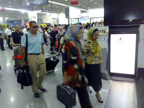8月10日凌晨,旅客從烏魯木齊地窩堡國際機場候機廳走出。新華社記者 沙達(dá)提 攝