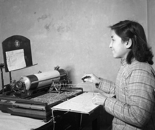 1960年,北京市郵局職工掀起了以機械化、半機械化為中心的技術革新和技術革命高潮。這是一部用舊中文打字機改裝的半機械化譯電機,過去譯電工作是按照來報的電碼用手工一字一字的翻寫出漢字來,如果電碼記的不熟,還要逐字翻閱電碼本,效率慢,有時還會出差錯。現(xiàn)在用譯電機翻譯,只要對準電碼一按,漢字就自動譯出來了,即使不會背譯電碼的人也可以使用(資料照片)。新華社發(fā)(資料照片)