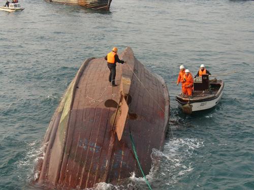 2005年12月9日,一艘遼寧籍漁船在渤海海域翻扣,船上10名船員1名逃生,4名船員獲救,5名失蹤。在得知海上險情后,交通部海事、救助部門和煙臺市各級政府立即投入海上救助,翻扣在船中的4名遇險船員被救上船。圖為此次海上救助現(xiàn)場。 新華社發(fā)