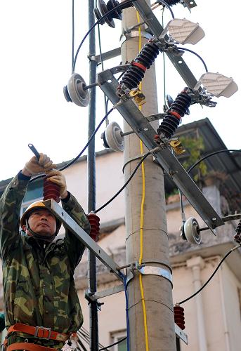 12月20日,江西定南縣供電公司一名工人在檢修電路。 新華社記者 周科 攝