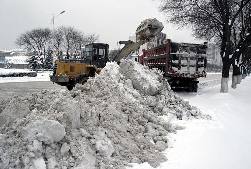 1月4日,清雪車(chē)輛在威海青島中路上清理積雪。 新華社發(fā)(于啟波 攝)
